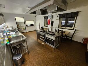 a kitchen with a stove and a sink and a table at Camp Mefjord in Senja
