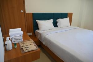 a bedroom with a bed and a table with towels at Shubhratna Hotel & Resort in Ujjain