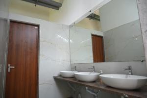 a bathroom with two sinks and a mirror at Shubhratna Hotel & Resort in Ujjain +36 photos