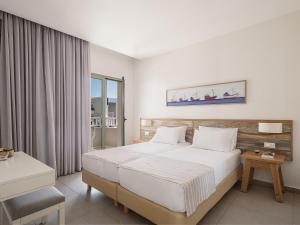 a hotel room with a bed and a window at Erato Beach Hotel Adults Only by Smile Hotels in Platanias +37 photos