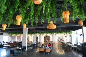 a restaurant with tables and chairs and potted plants at Shubhratna Hotel & Resort in Ujjain