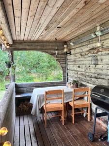 a table and two chairs on a wooden deck at Mysig timmerstuga med sjötomt in Grangärde