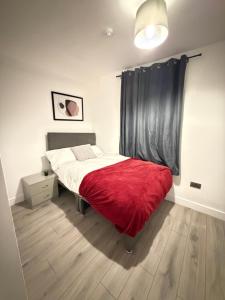a bedroom with a bed with a red blanket at Upton House in Chatham