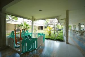 a playground with green chairs and a slide at Hotel Grand Rosela in Yogyakarta