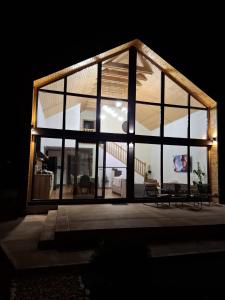a large glass house with a large window at Nordic Cabin in Bughea de Jos