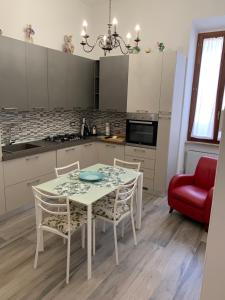 a kitchen with a table and chairs and a red couch at Palazzo Elisei in Gubbio