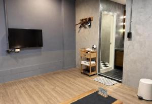 a bathroom with a flat screen tv on a wall at 境域Loft自助民宿 in Kaohsiung +50 photos