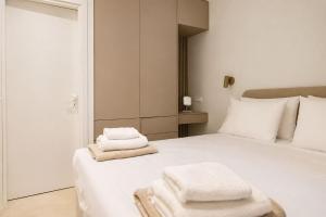 a bedroom with a white bed with towels on it at Gialova Sunset Apartment in Gialova +13 photos