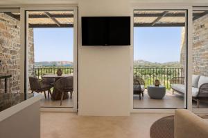 a living room with a tv on a wall at Gialova Sunset Apartment in Gialova