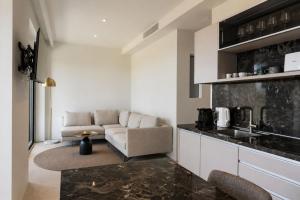 a living room with a couch and a kitchen at Gialova Sunset Apartment in Gialova