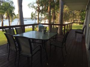 a table and chairs on a deck with a view of the water at Starfish Cottage in Cams Wharf