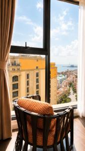 a room with a large window with a table and chairs at ELIO PHÚ QUỐC - Hillside Residence in Phú Quốc