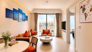 a living room with a couch and a table at ELIO PHÚ QUỐC - Hillside Residence in Phú Quốc