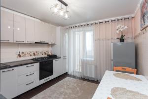 a kitchen with white cabinets and a refrigerator at Ion Creangă Residence in Chişinău