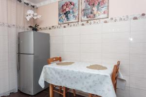 a kitchen with a table and a refrigerator at Ion Creangă Residence in Chişinău