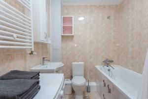 a bathroom with a toilet and a sink and a tub at Ion Creangă Residence in Chişinău +16 photos