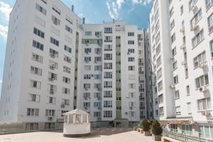 a large white building with a small house in front of it at Ion Creangă Residence in Chişinău