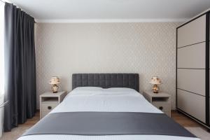 a bedroom with a large bed with two night stands at Ion Creangă Residence in Chişinău