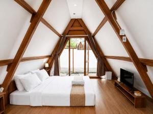 a bedroom with a bed and a tv in a attic at New Dgyp Ciater Resort in Ciater +20 photos
