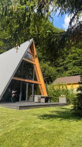 a house with a large window in a yard at Mia A-Frame Chalet Cheia in Cheia