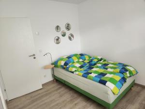 a bedroom with a bed with a colorful blanket at Borndal-Zeit in Altenberge
