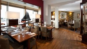 a dining room with wooden tables and chairs at CK Serviced Apartments, Titanic Quarter, Belfast in Belfast