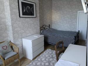 a small bedroom with a bed and a chair at Maison Marcadieu in Maubourguet