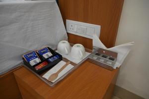 a bedroom with a bed and a night stand with food at Shubhratna Hotel & Resort in Ujjain