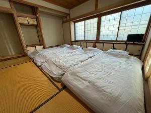 a large bed in a room with two windows at Laina 31 in Sumoto