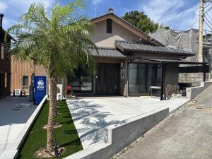 a house with a palm tree in front of it at Laina 31 in Sumoto