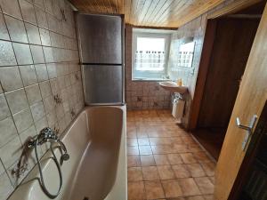 a small bathroom with a tub and a sink at Hofruhe in Neresheim