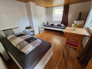 a bedroom with a large bed and a desk and a table at Hofruhe in Neresheim