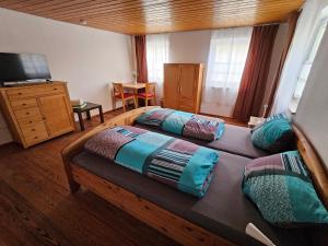 a bedroom with two beds and a television in it at Hofruhe in Neresheim