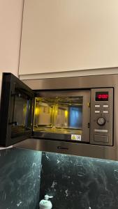 a microwave oven with its doors open in a kitchen at Il Glicine in Cusano Milanino