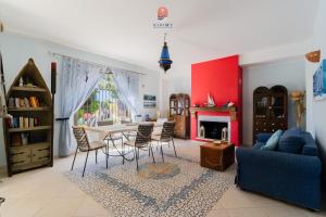 a living room with a blue couch and a table and chairs at Casina dei Capperi by Vivimy in Torre Pali