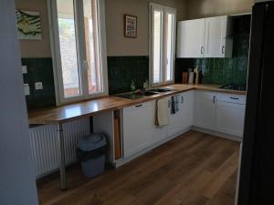 a kitchen with white cabinets and a wooden counter top at Maison Marcadieu in Maubourguet
