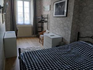 a bedroom with a bed and a chair and a window at Maison Marcadieu in Maubourguet