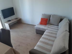 a living room with a couch and a television at Apartman Jednosoban, Dvosoban, Trosoban in Sukošan