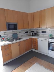 a kitchen with wooden cabinets and white appliances at Gästrum in Halmstad +9 photos