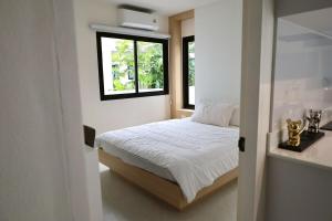a small bedroom with a bed and a window at Chiang Rai Home with Full Kitchen in Ban Pa Sang (1)