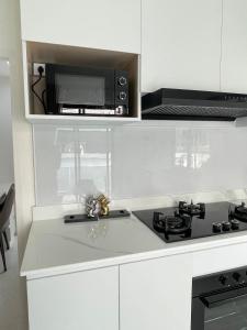 a white kitchen with a stove and a microwave at Chiang Rai Home with Full Kitchen in Ban Pa Sang (1)