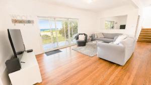 a living room with a couch and a tv at On The Beach in Wooli