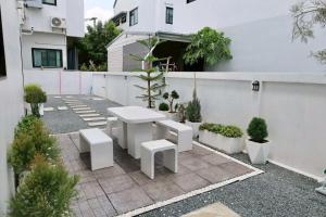 a patio with a white table and benches at Chiang Rai Home with Full Kitchen in Ban Pa Sang (1)