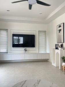 a living room with a flat screen tv on a wall at Chiang Rai Home with Full Kitchen in Ban Pa Sang (1)