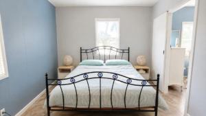 a bedroom with a black bed in a white room at The Blue Groper in Minnie Water