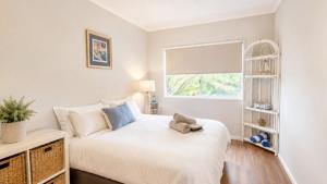 a bedroom with a bed with a teddy bear on it at Surfside in Wooli