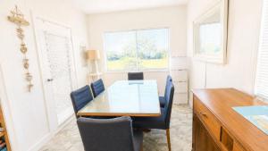 a dining room table with chairs and a desk at The Blue Groper in Minnie Water
