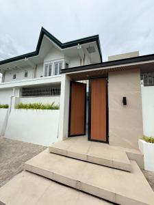 a white house with brown doors and a driveway at Casa Sakura 2 in Calamba +1 photo