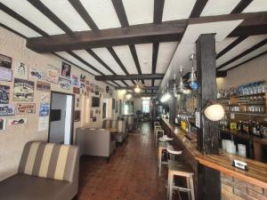 a restaurant with a bar with chairs and tables at Auberge du sichon in Ferrières-sur-Sichon