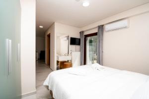 a white bedroom with a bed and a window at Ligiades 945 in Ligiades